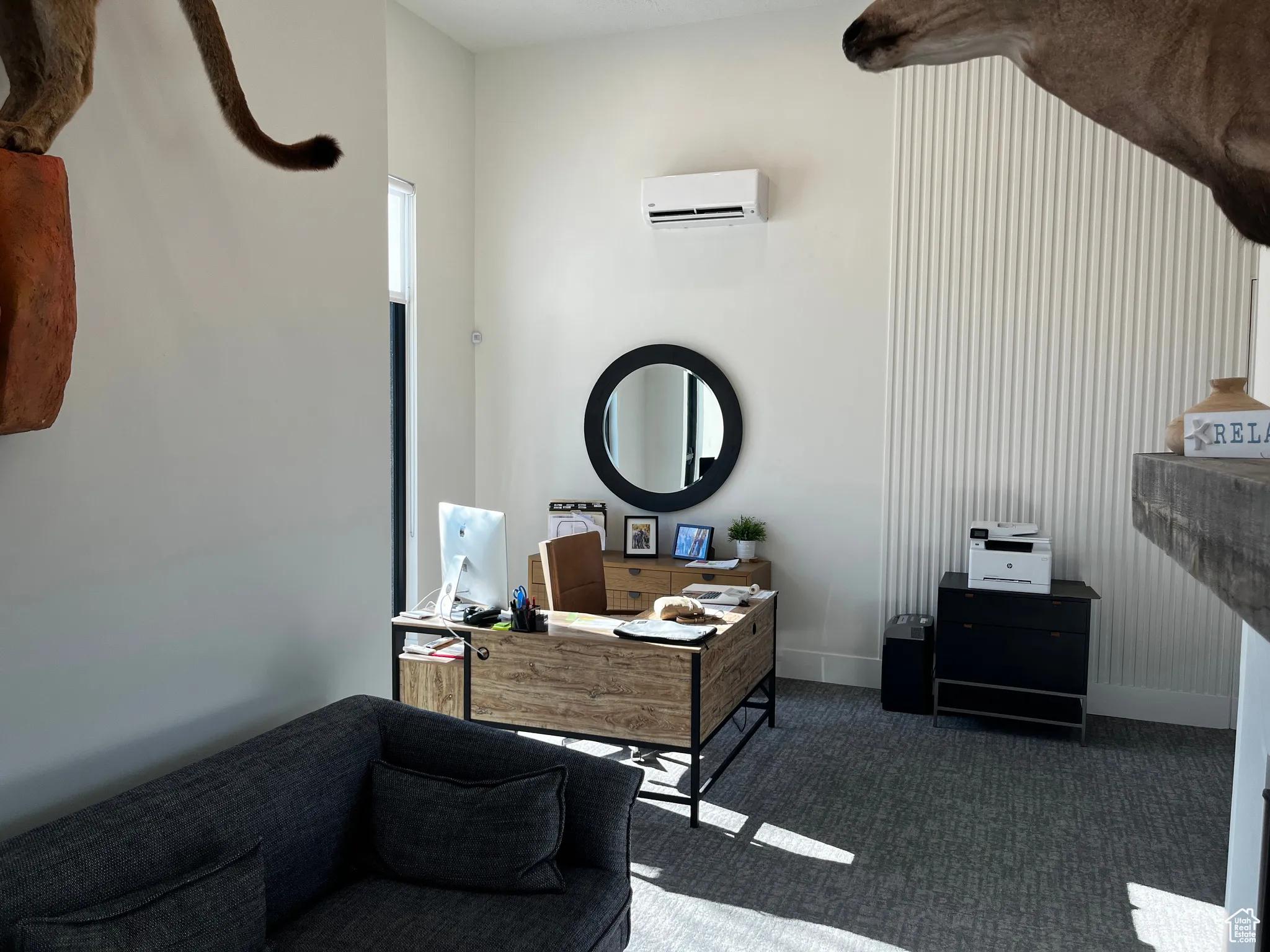 Interior space with baseboards, an AC wall unit, and dark colored carpet