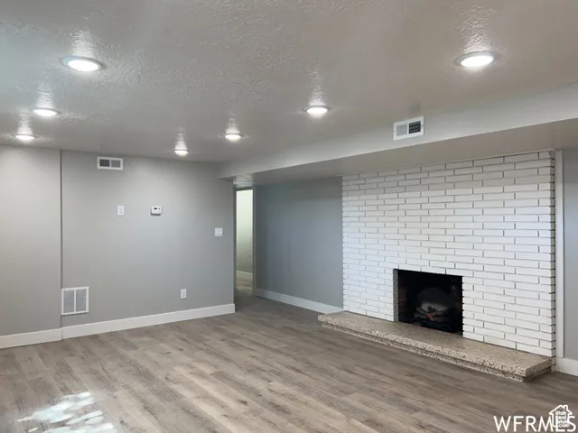 Unfurnished living room with visible vents and wood finished floors