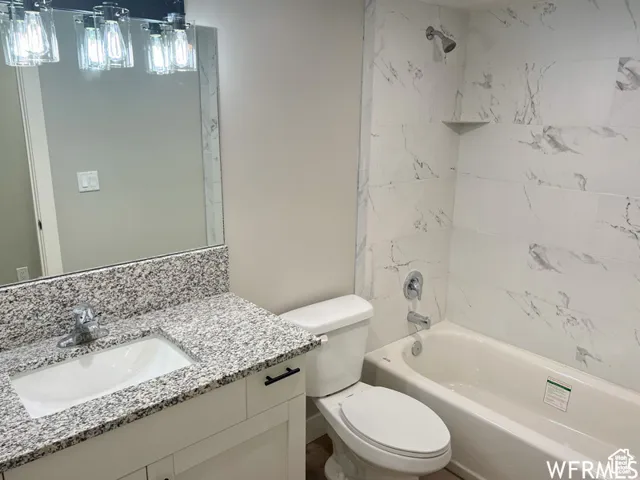 Bathroom featuring toilet, vanity, and shower / bathing tub combination