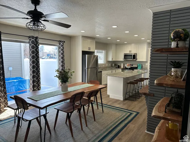 Dining space with a wealth of natural light, light wood-style flooring, recessed lighting, and a ceiling fan