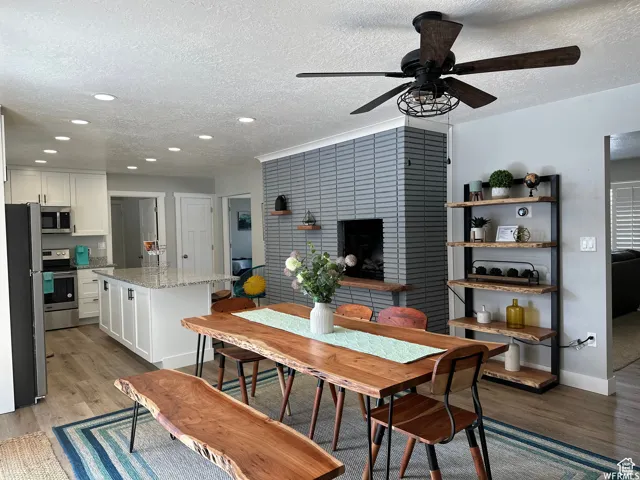 Dining space with recessed lighting, baseboards, a textured ceiling, ceiling fan, and light wood-style flooring