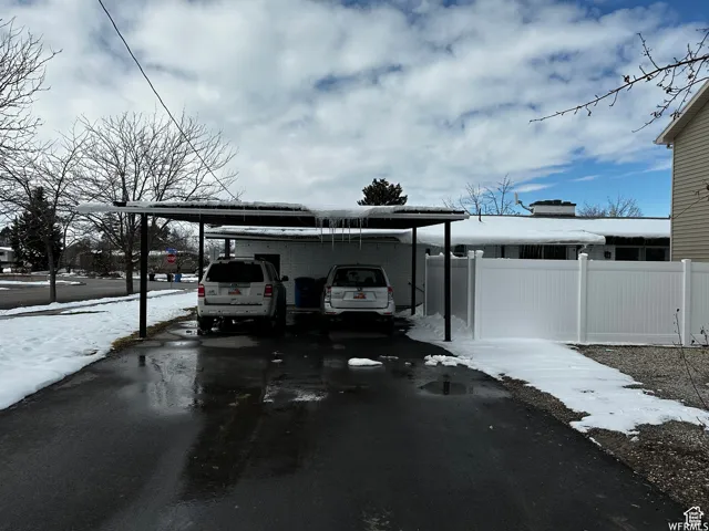 Exterior space with driveway, fence, and an attached carport