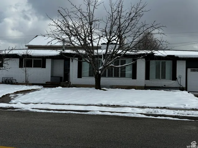 View of front of house featuring brick siding and an attached garage