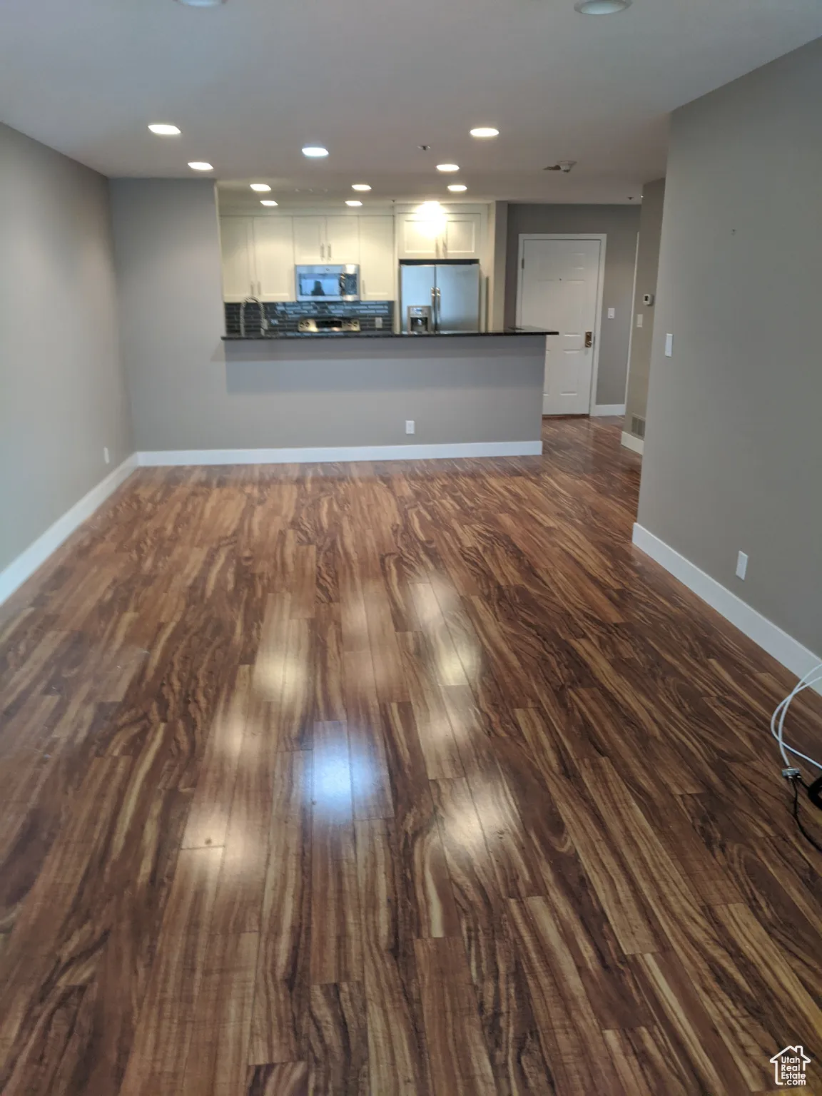 Living room featuring recessed lighting, baseboards, and dark wood finished floors.  Please note that the condo is fully furnished.