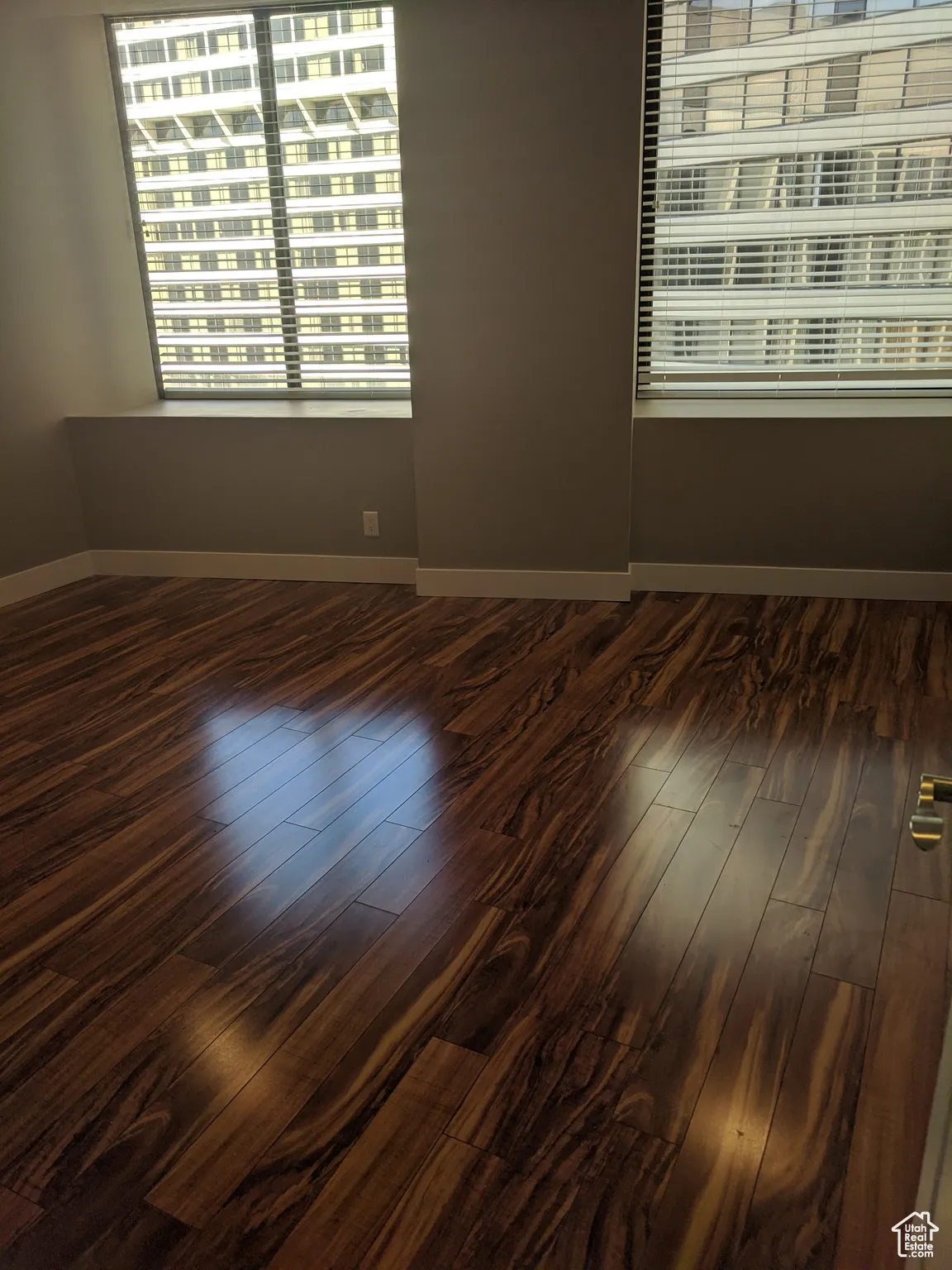 Spare room with baseboards and dark wood finished floors.  The condo is currently fully furnished.