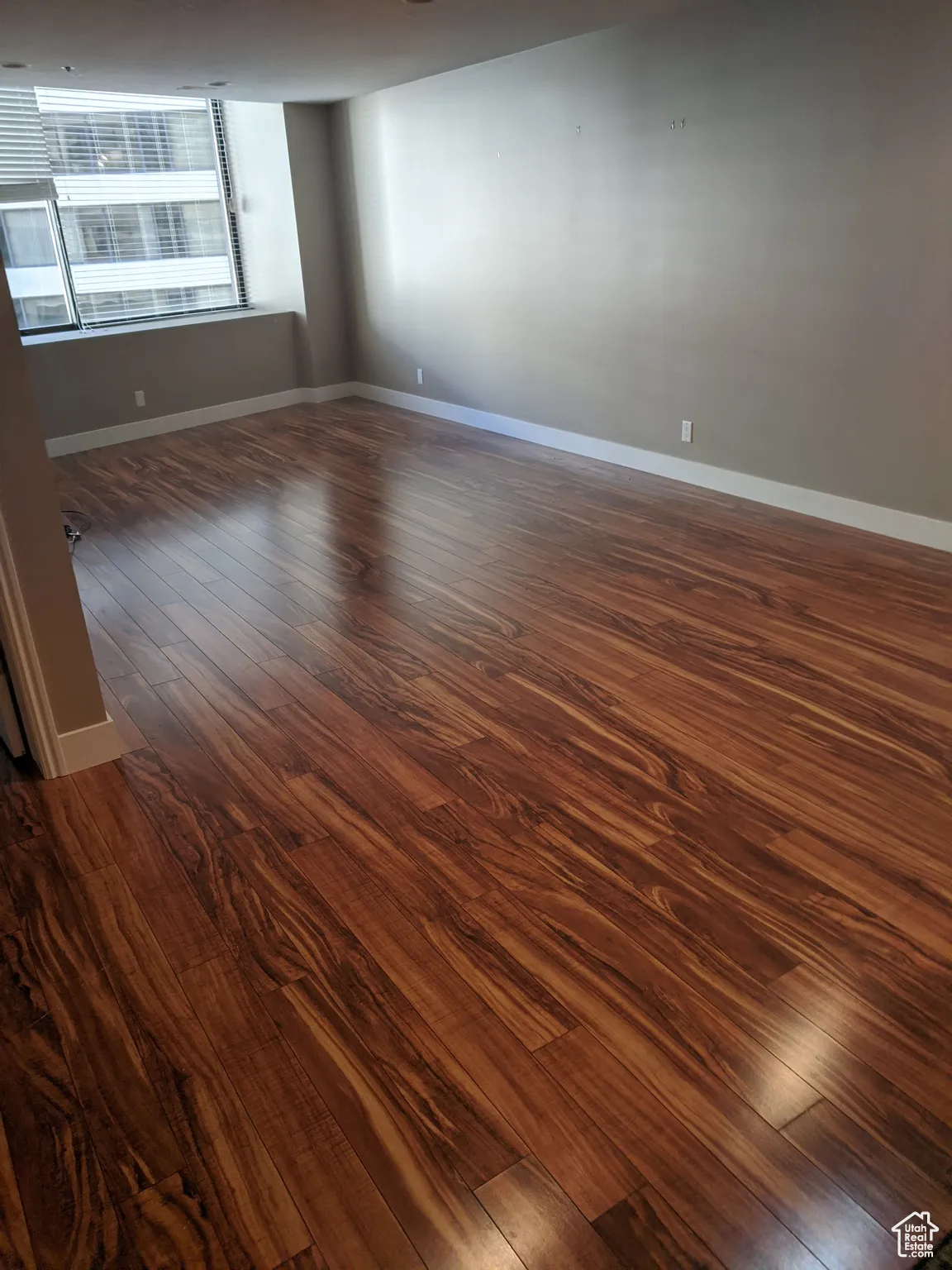 Living room featuring dark wood-style flooring and baseboards.  The condo is fully furnished.