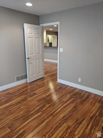 Spare room with baseboards, visible vents, recessed lighting, and dark wood finished floors