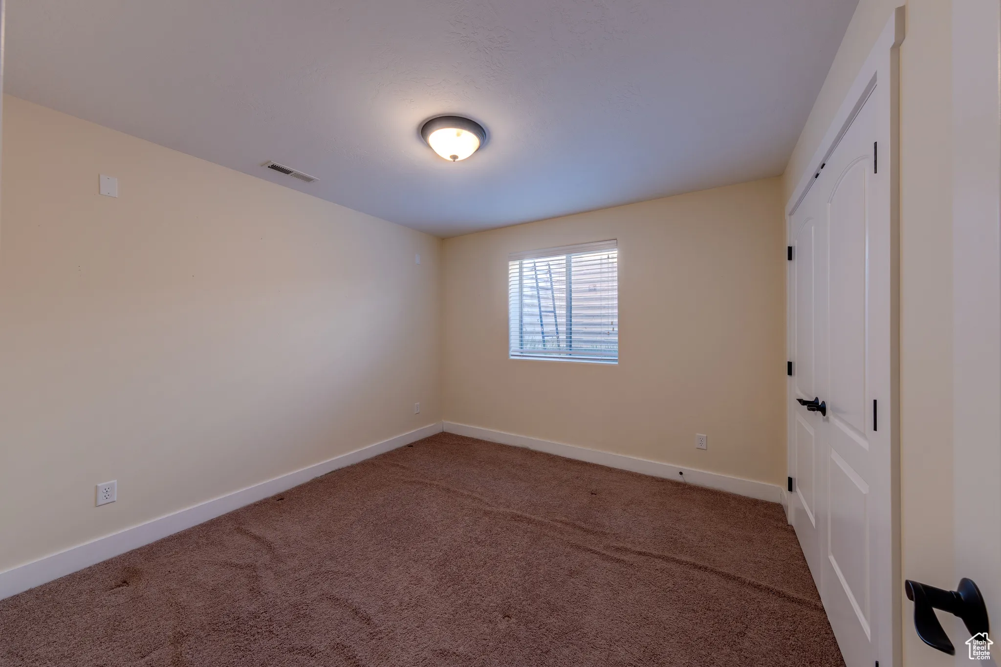 Unfurnished room featuring baseboards, visible vents, and carpet floors
