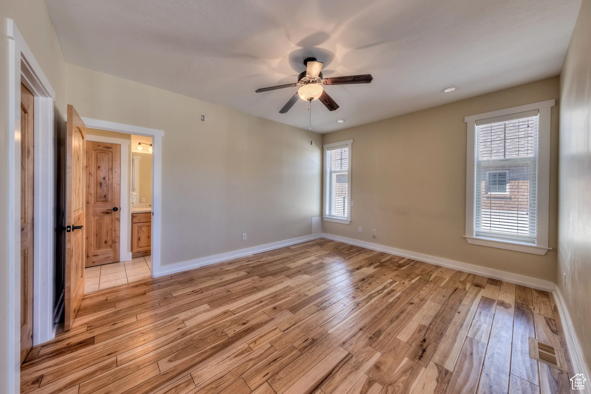 Interior space with baseboards, light wood-style flooring, and ceiling fan