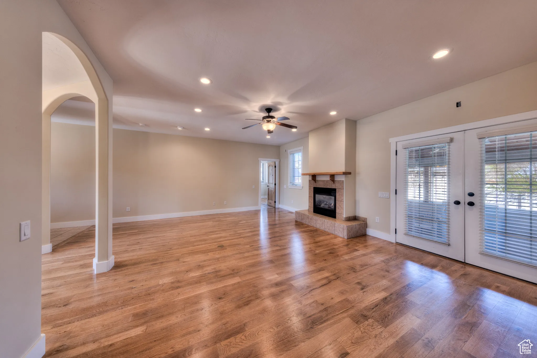 Unfurnished living room with ceiling fan, recessed lighting, french doors, and light wood-style floors