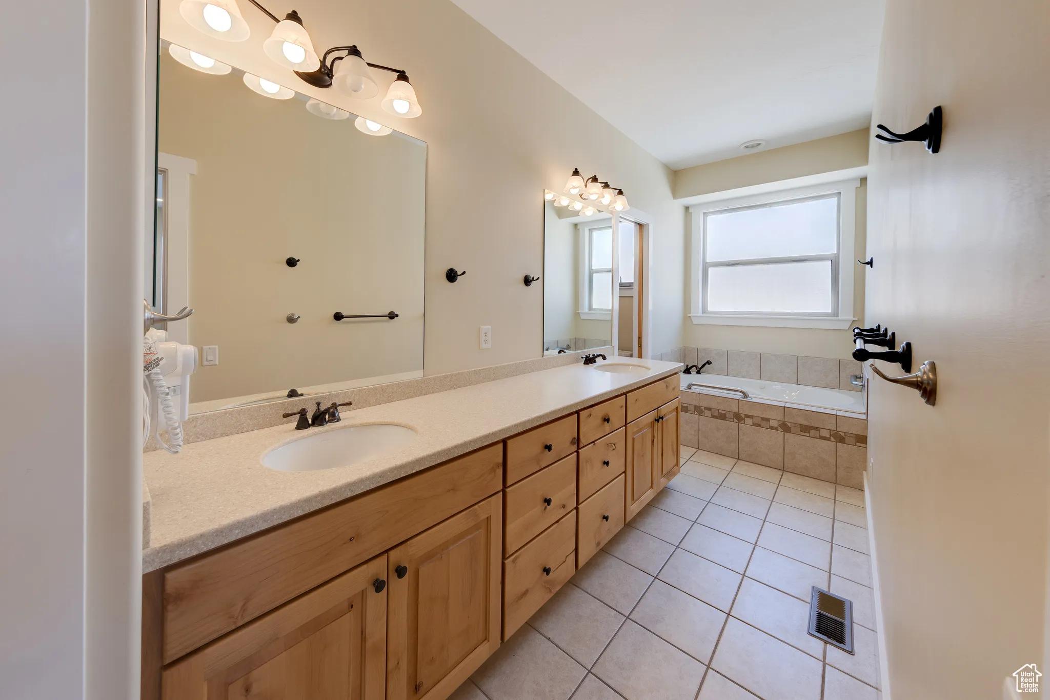 Full bathroom featuring tile patterned flooring, a sink, visible vents, and a bath