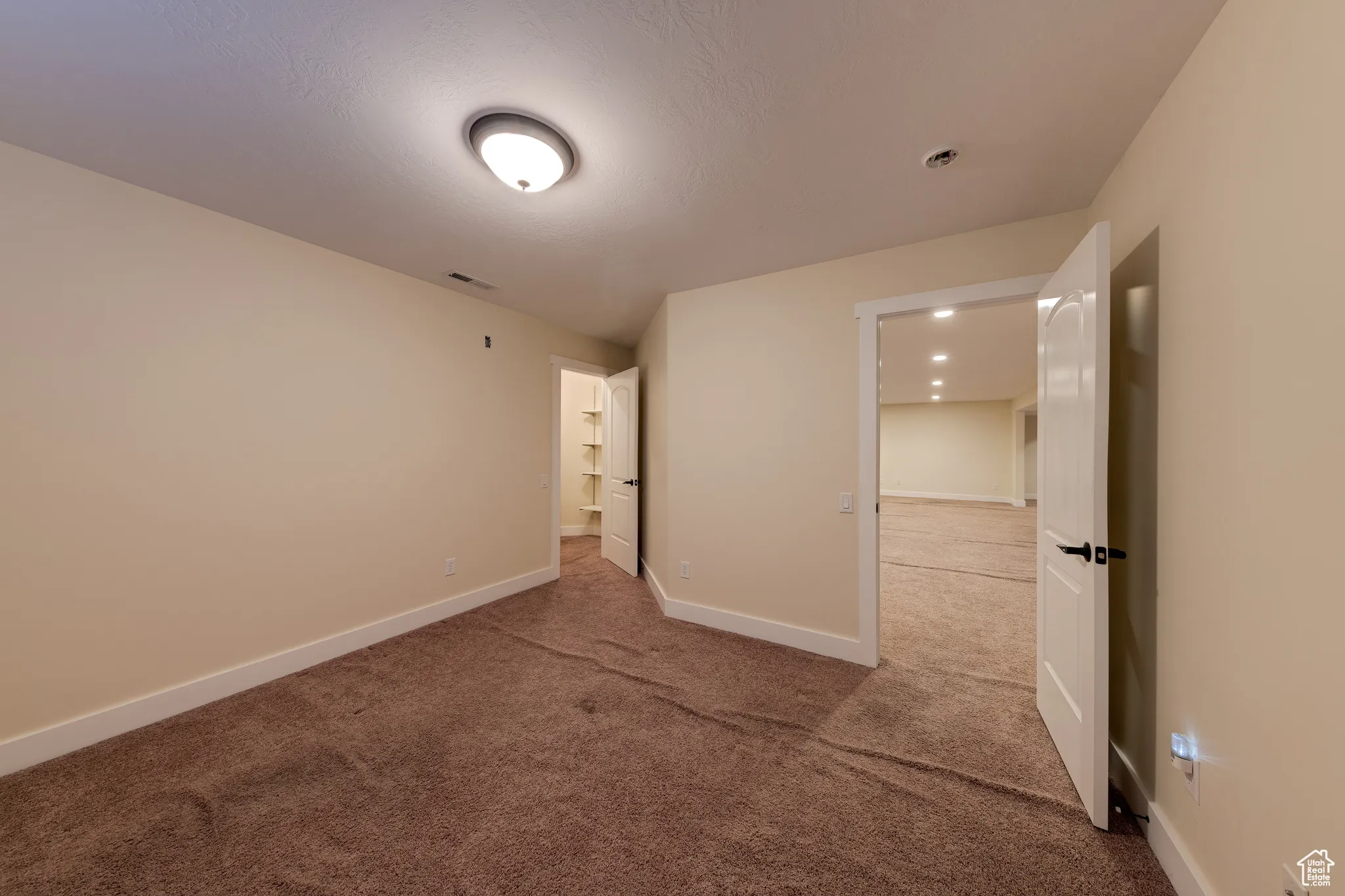Unfurnished bedroom featuring baseboards, visible vents, and carpet