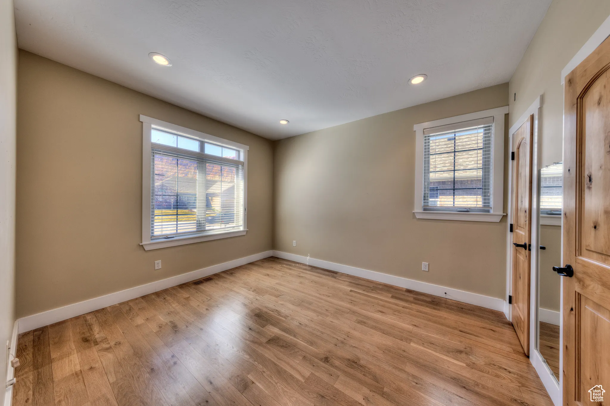 Unfurnished room featuring light wood finished floors, baseboards, and recessed lighting