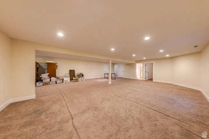 Finished basement with baseboards, visible vents, recessed lighting, and carpet