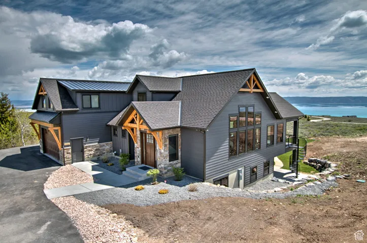 View of front of home with a water view, aphalt driveway, and an attached garage