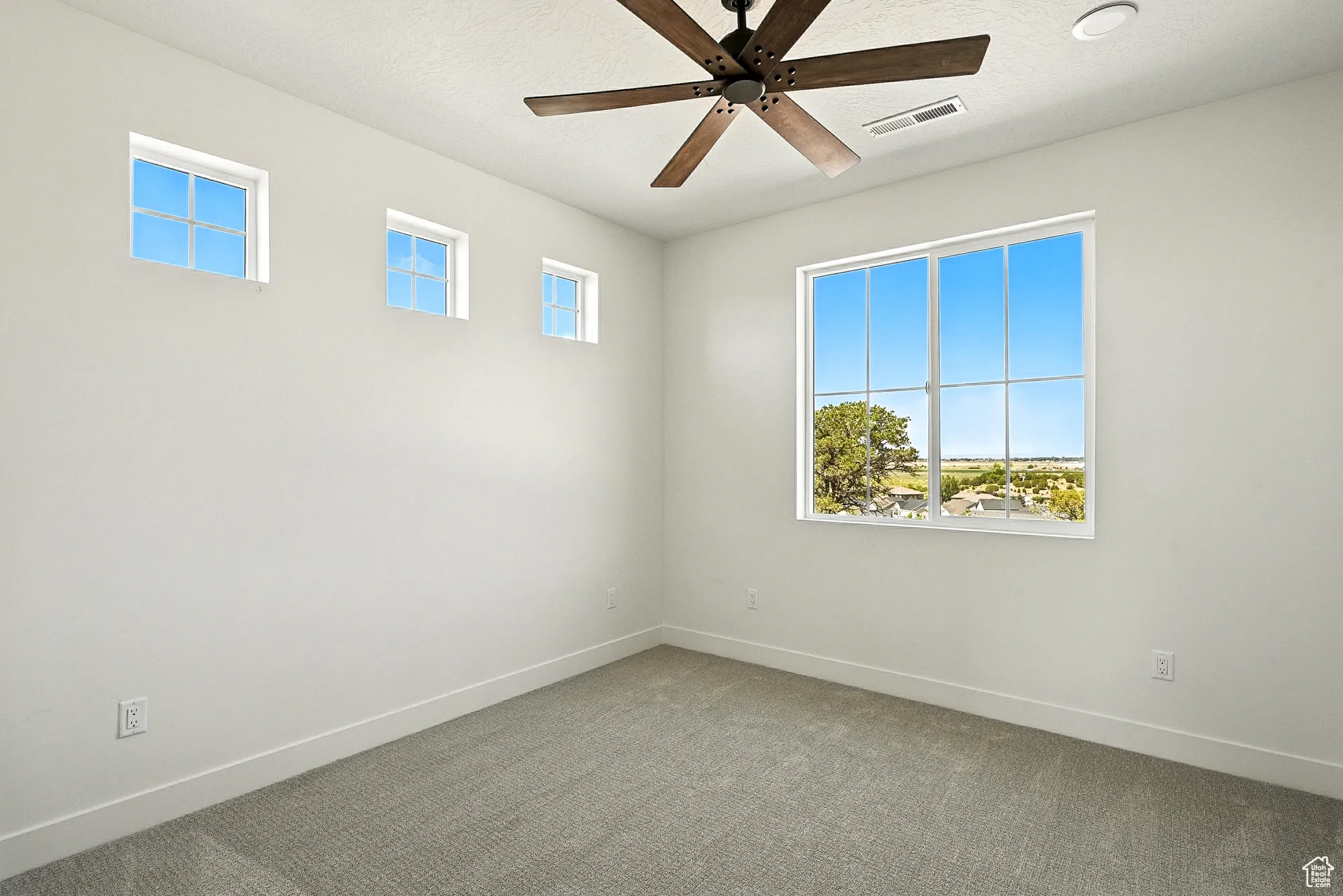 Spare room featuring ceiling fan and carpet