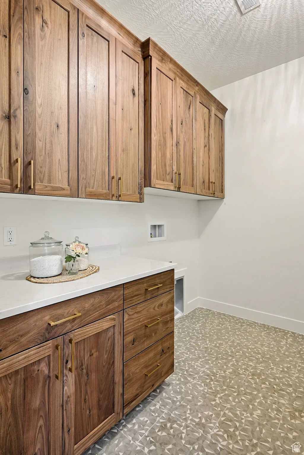 Washroom featuring cabinet space, a textured ceiling, and washer hookup