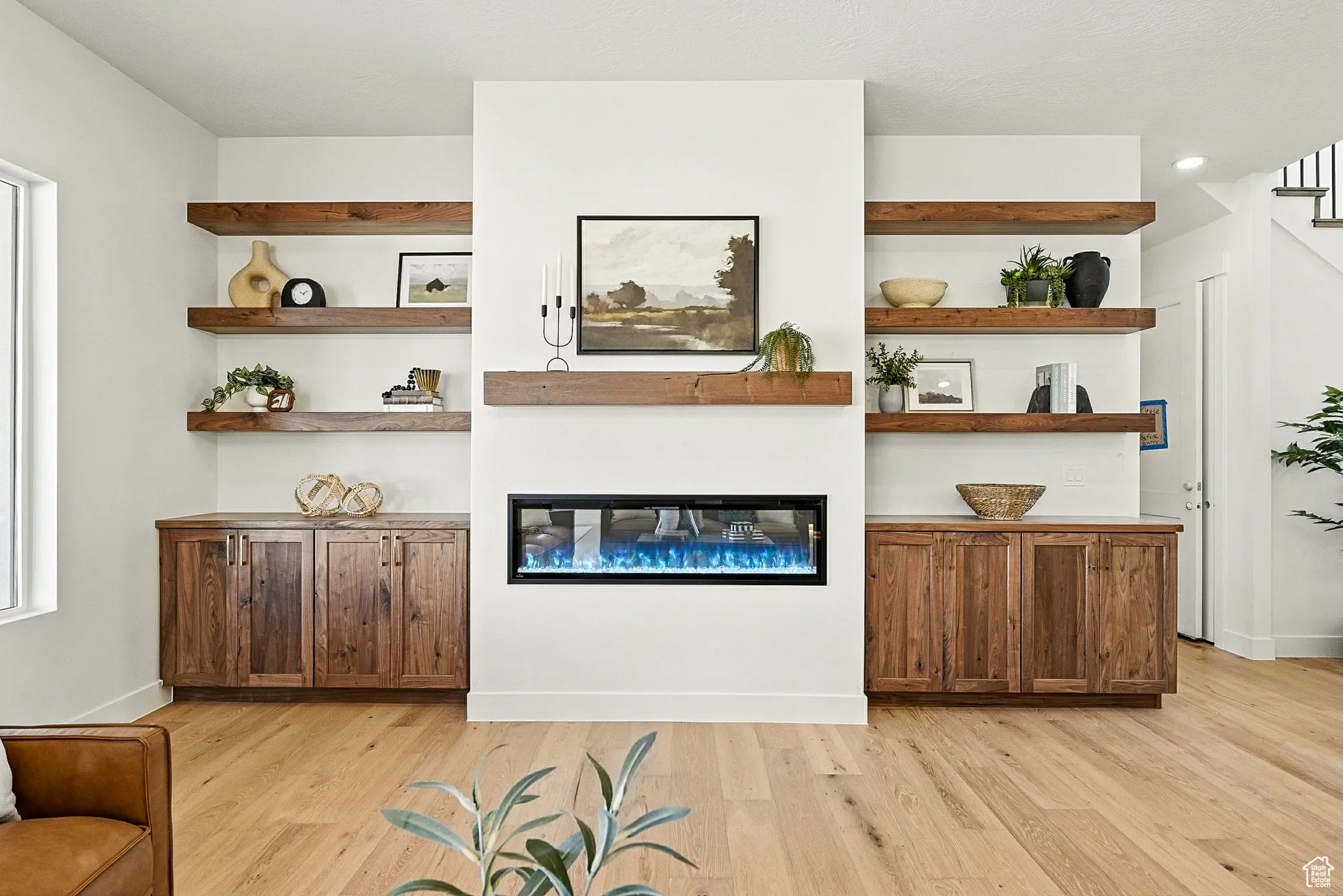 Living area with a glass covered fireplace and light wood-type flooring