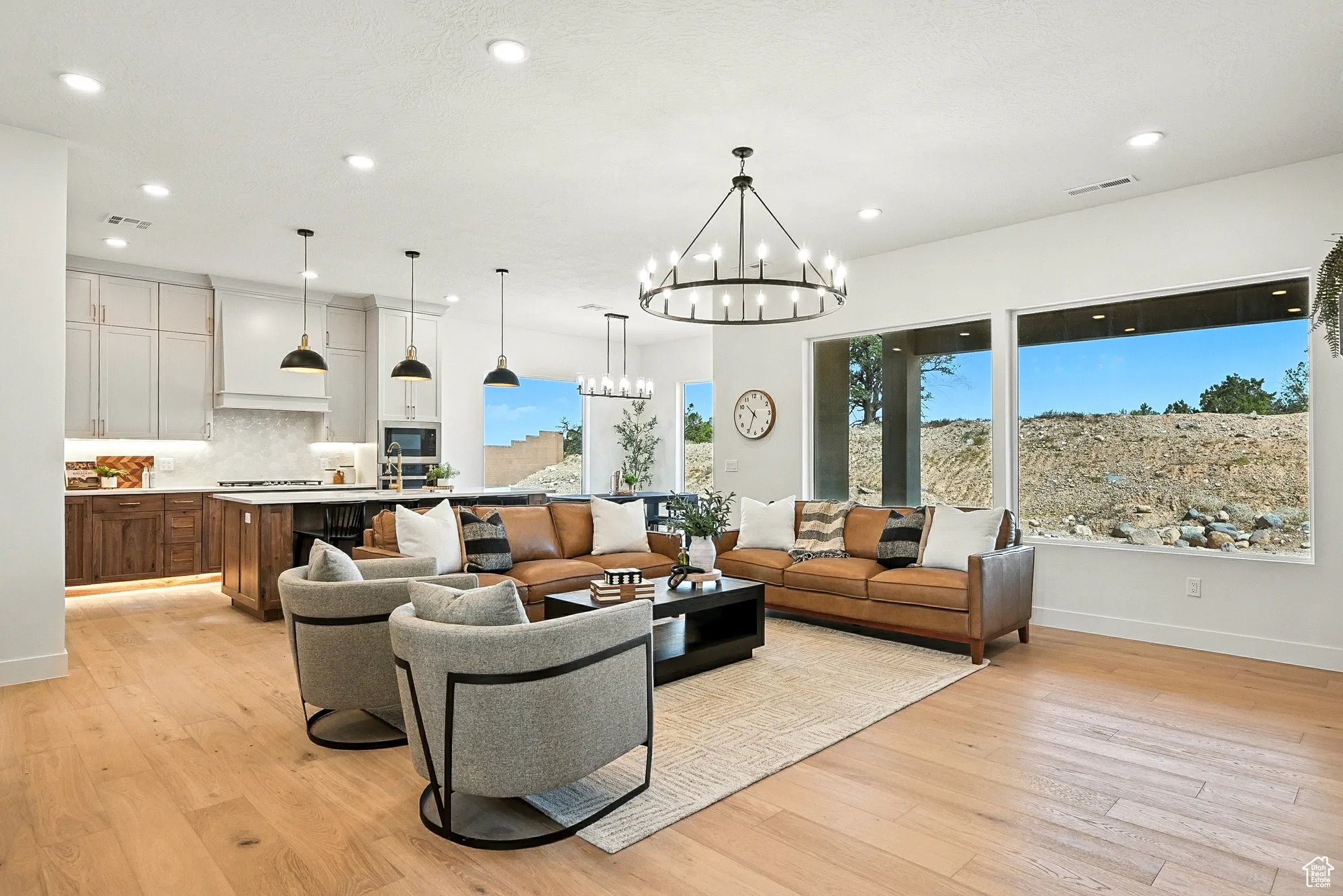 Living area featuring light wood finished floors, a chandelier, and recessed lighting