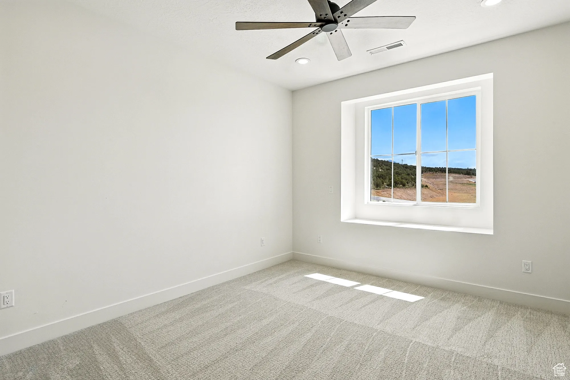 Spare room with carpet floors, a ceiling fan, and recessed lighting