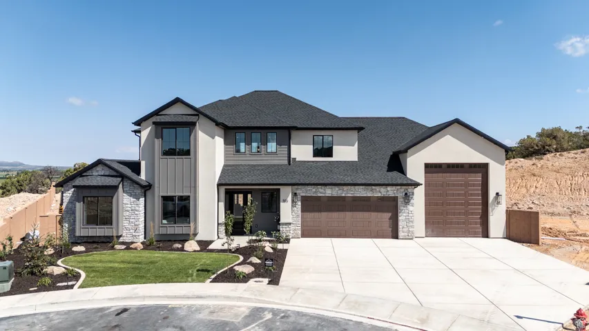 Modern farmhouse style home with stone siding, a shingled roof, concrete driveway, and a front lawn