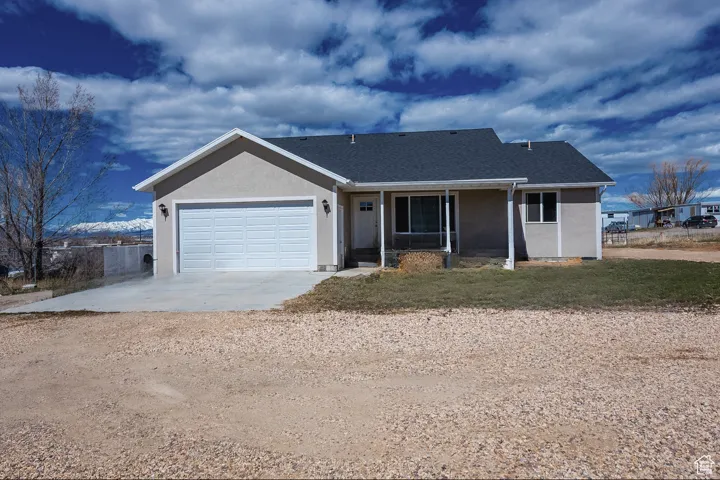Ranch-style house featuring stucco siding, concrete driveway, a garage, and roof with shingles