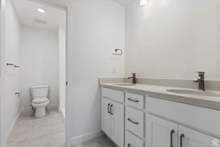 Full bathroom featuring visible vents, toilet, tile patterned flooring, and a sink