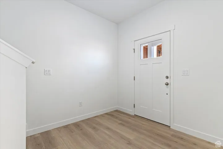 Entryway with baseboards and light wood finished floors