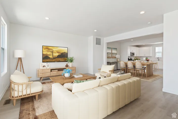 Living area with recessed lighting, light wood-style floors, and visible vents