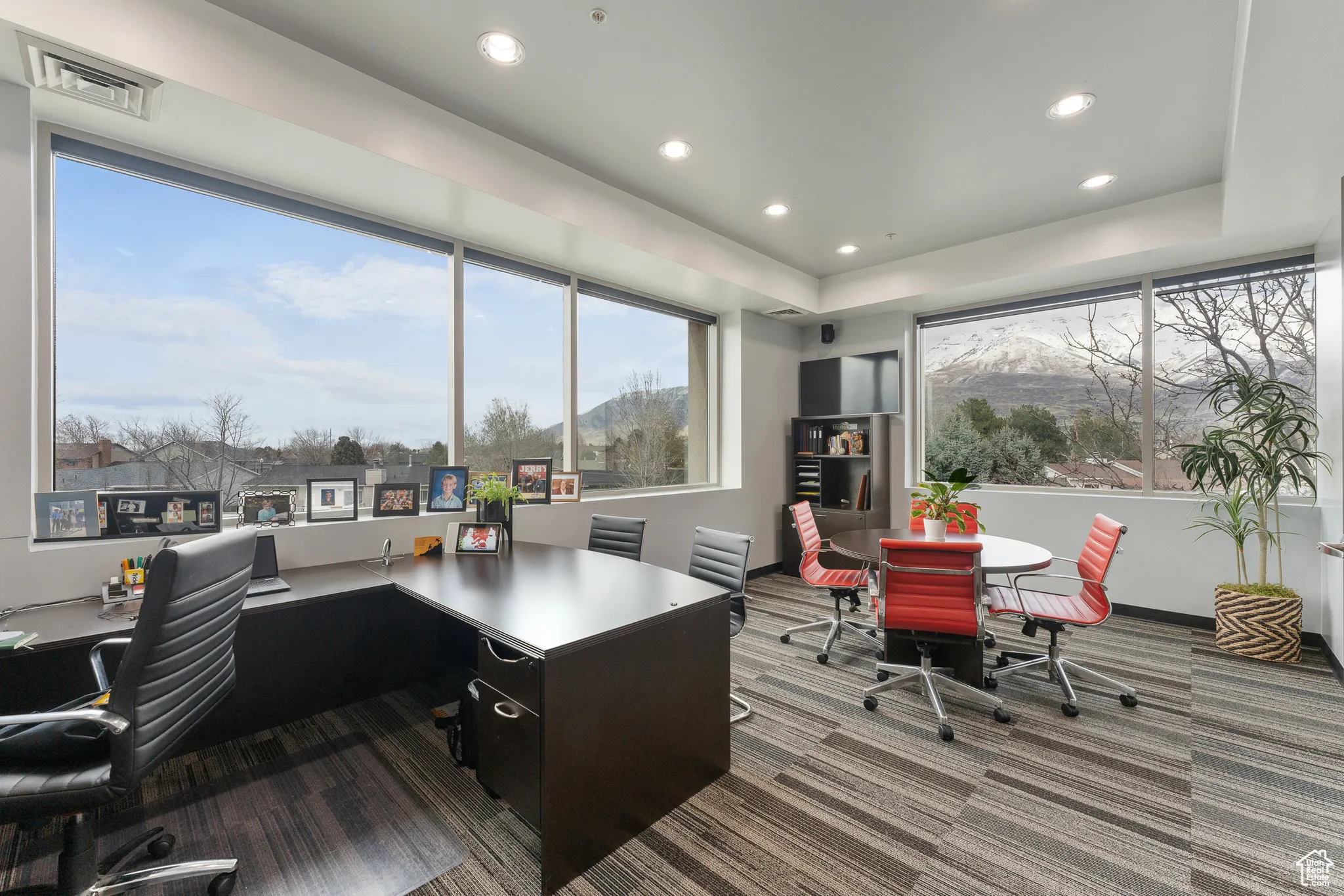 Carpeted home office with a raised ceiling, recessed lighting, and visible vents