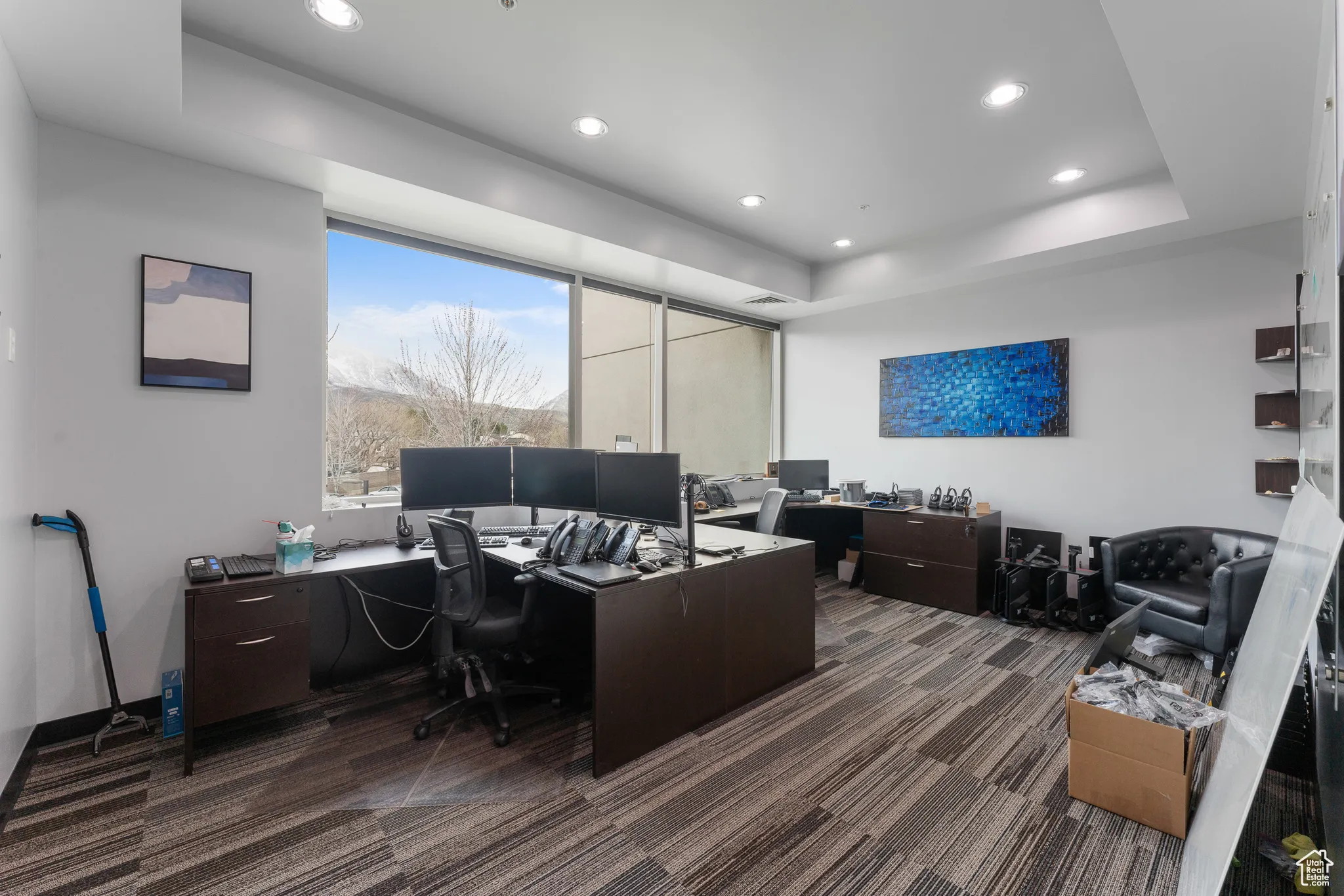 Office space with a raised ceiling, visible vents, carpet, and recessed lighting