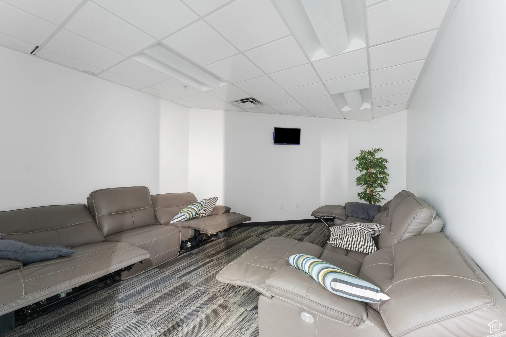 Living area with visible vents and a drop ceiling