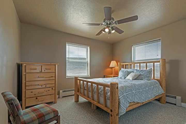 Carpeted room with neutral wall tones and a ceiling fan with integrated lighting