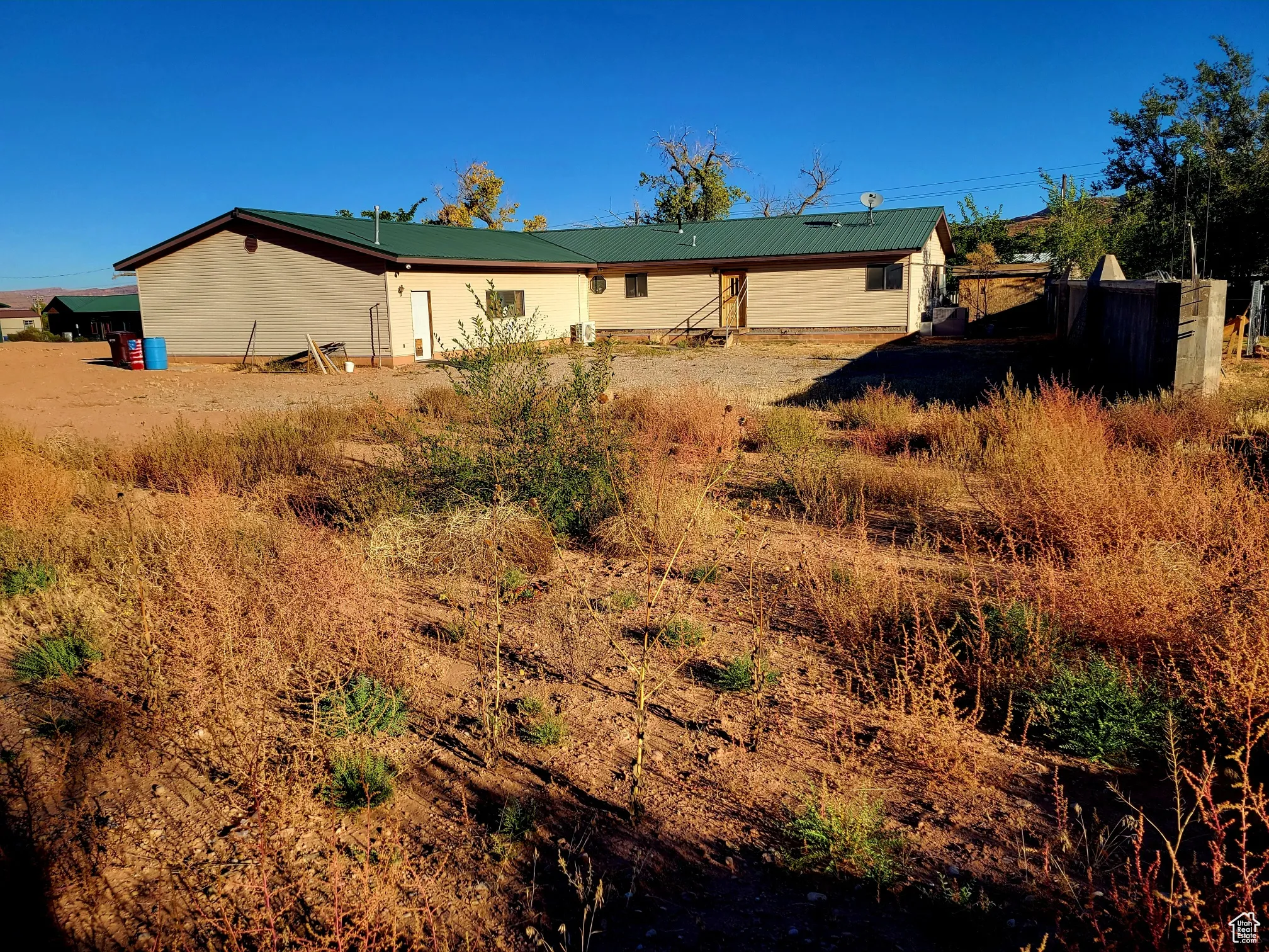 Back of house with metal roof and fence
