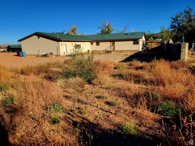 Back of house with metal roof and fence
