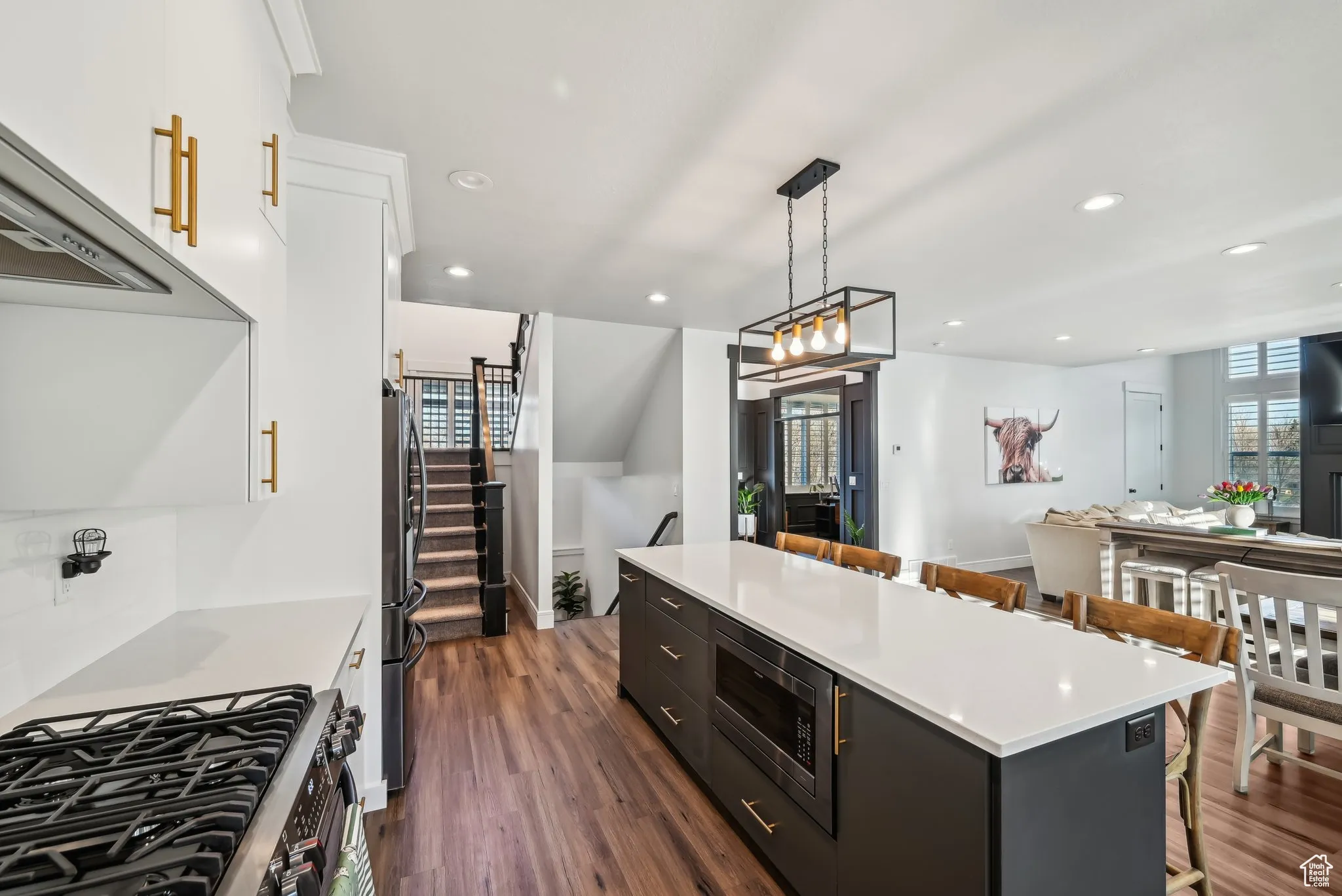 Kitchen with a center island, white cabinets, a breakfast bar, and appliances with stainless steel finishes