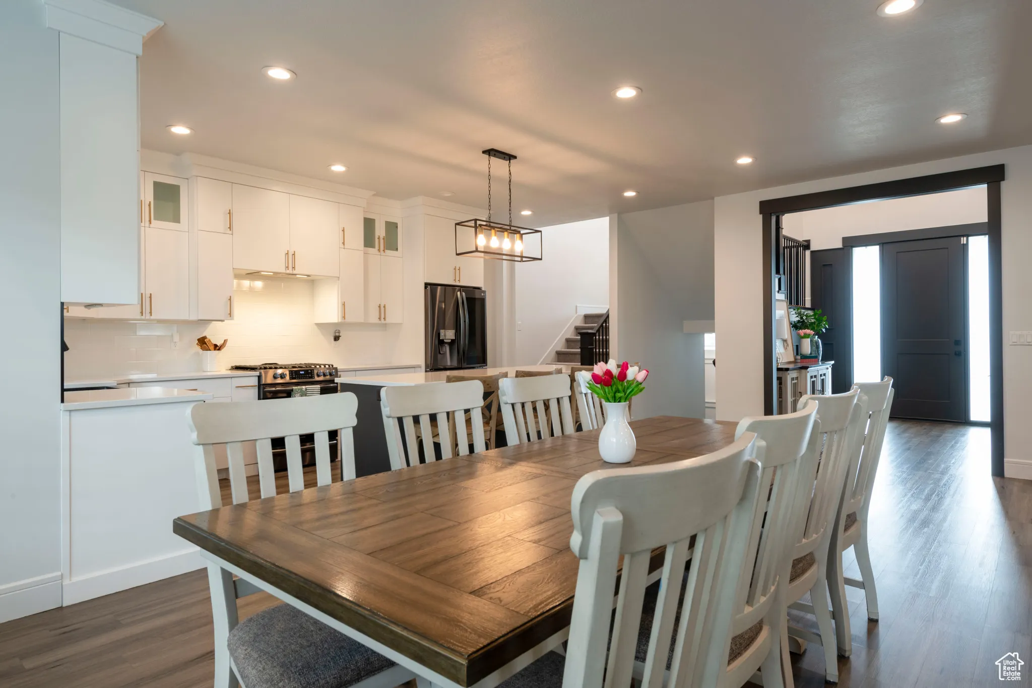 Dining space with stairs, recessed lighting, and dark wood finished floors