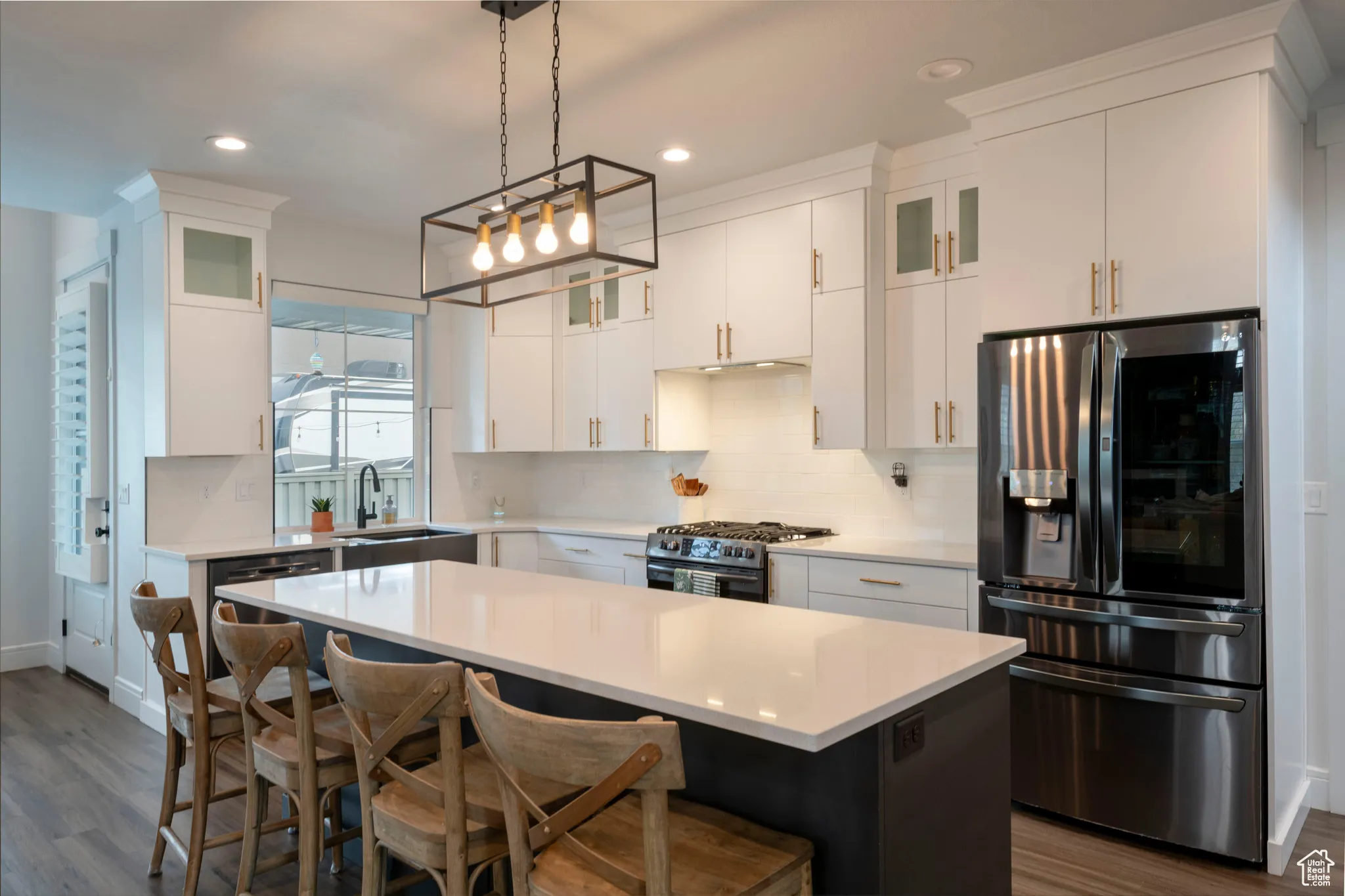 Kitchen featuring light countertops, a sink, stainless steel appliances, and decorative backsplash
