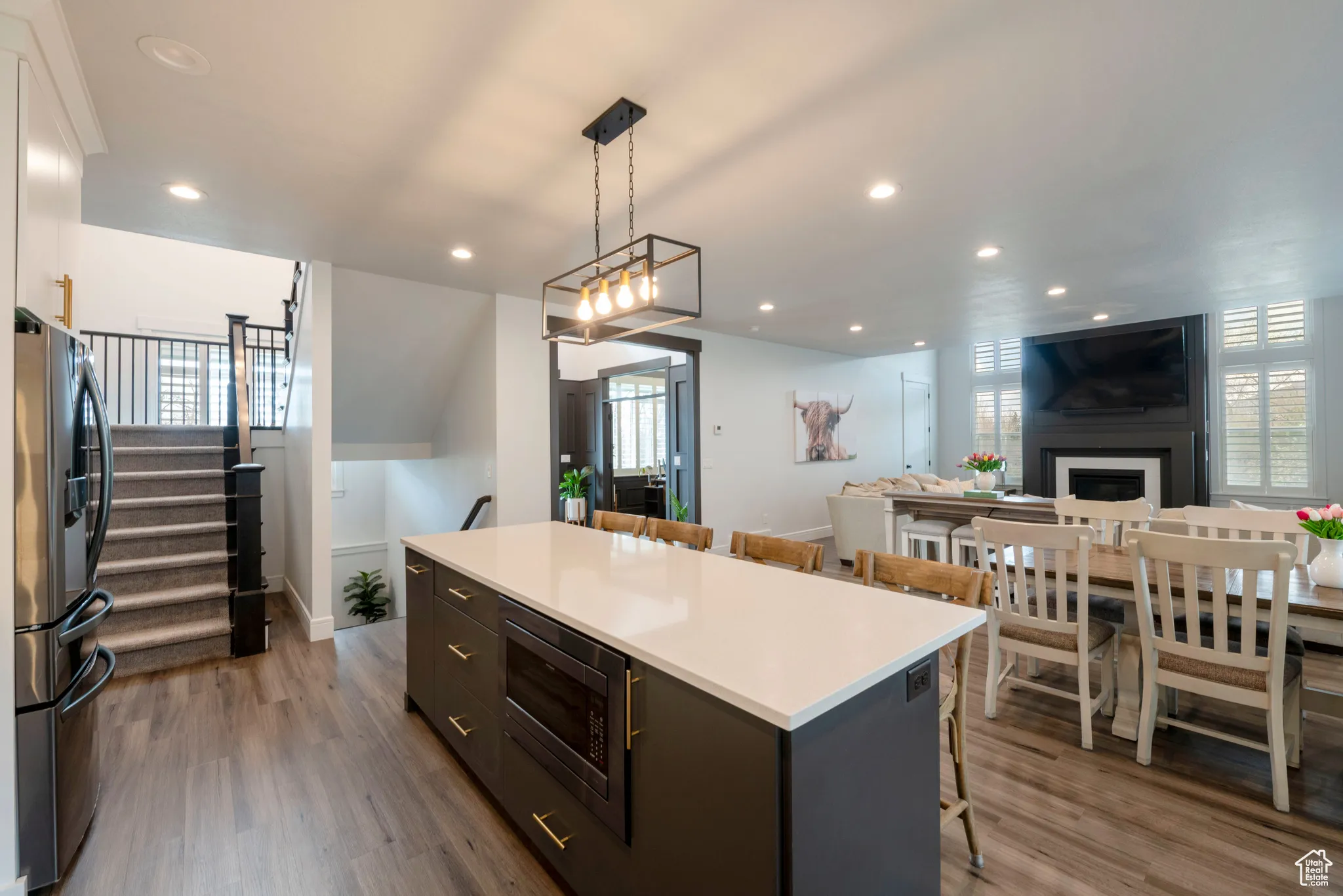 Kitchen with a kitchen breakfast bar, dark wood-style floors, a kitchen island, and appliances with stainless steel finishes
