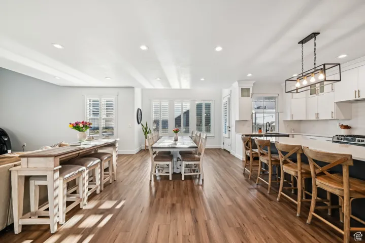 Dining space with wood finished floors, baseboards, and recessed lighting