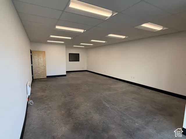 Expansive open-concept room featuring concrete flooring and white walls