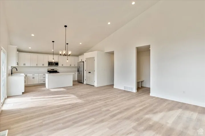 Kitchen with visible vents, a center island, open floor plan, light countertops, and appliances with stainless steel finishes