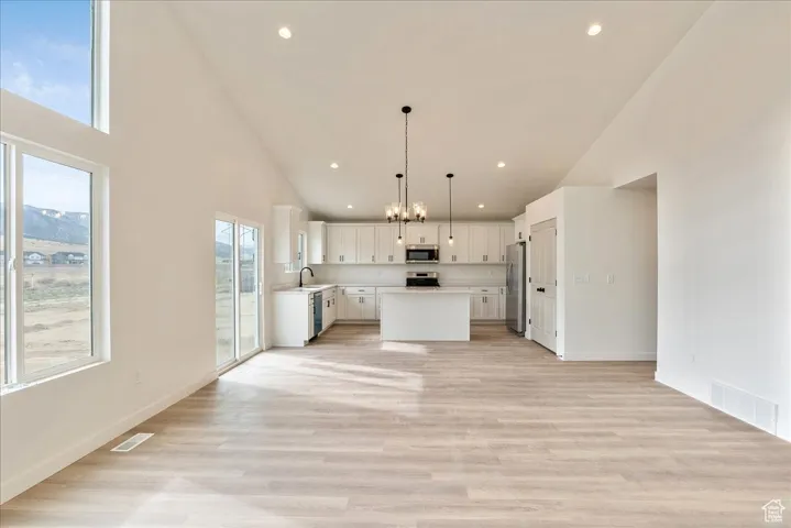 Kitchen with visible vents, open floor plan, light countertops, and stainless steel appliances