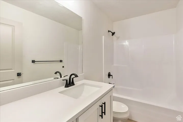 Bathroom with toilet, vanity, and shower / bathing tub combination