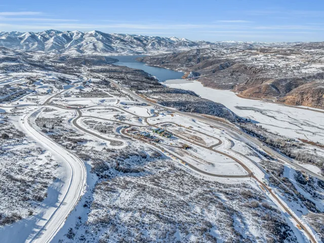 Snowy aerial view featuring a water and mountain view