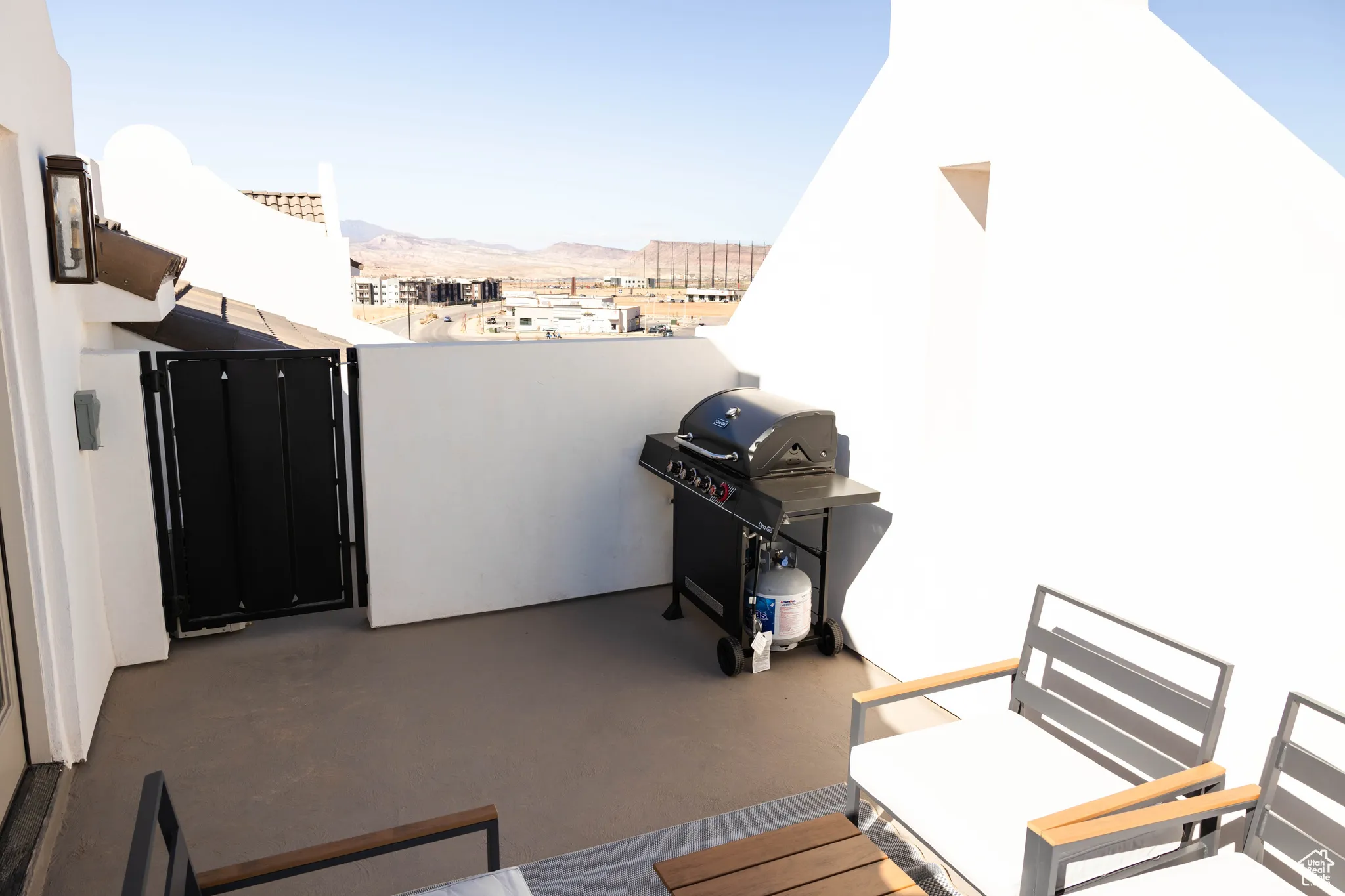 View of patio featuring a grill, a mountain view, and a balcony