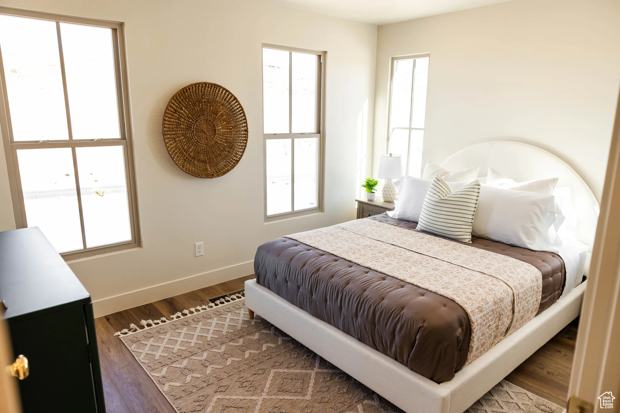 Bedroom featuring wood finished floors, baseboards, and multiple windows