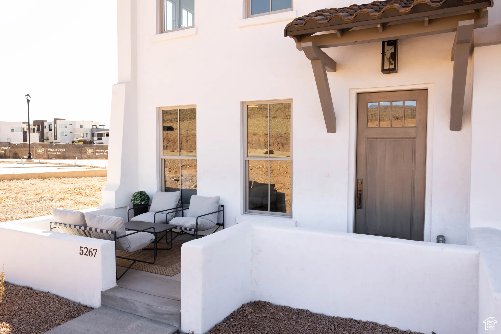 View of exterior entry with a porch, stucco siding, and a tile roof