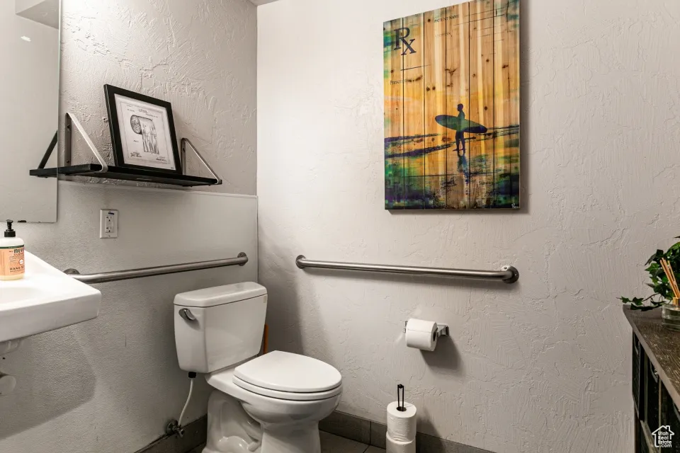 Half bath with toilet and a textured wall