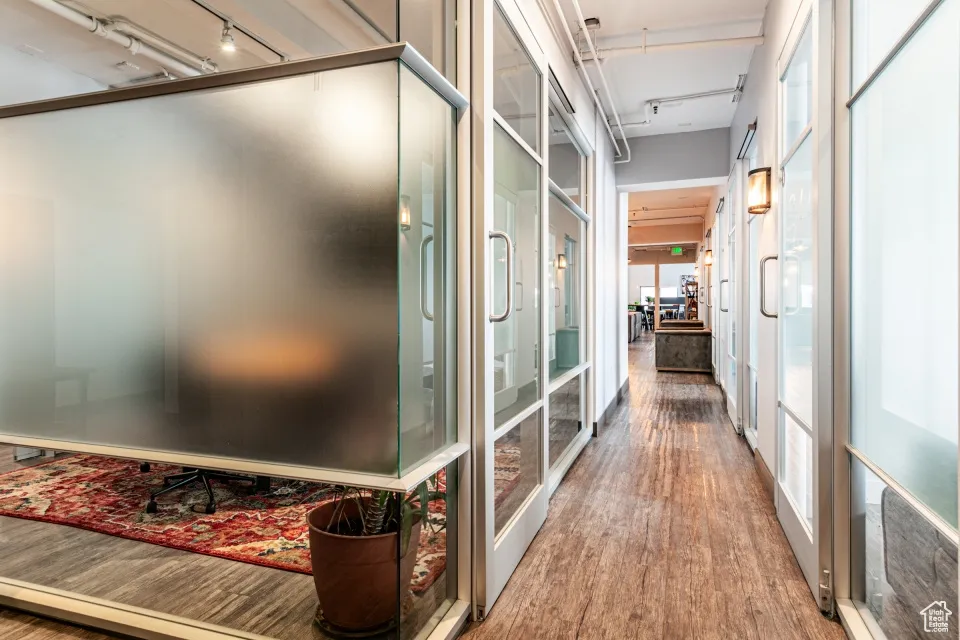 Hallway featuring rail lighting and wood finished floors